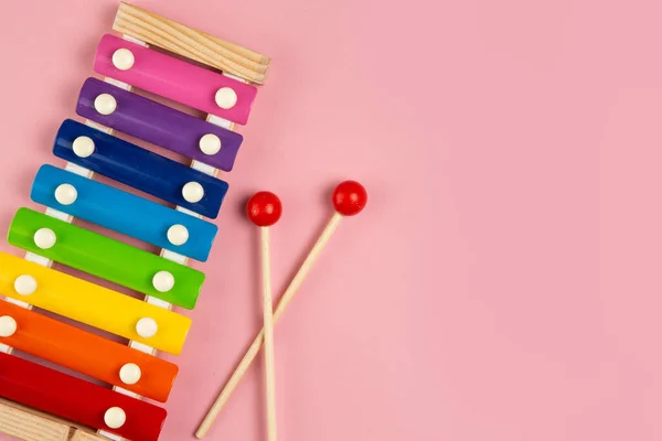 Gökkuşağı renkli oyuncak ksilofon pembe arka planda izole edilmiş..