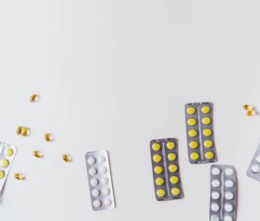 Beyaz bir arka planda hap kabarcıkları ve dağınık haplar.