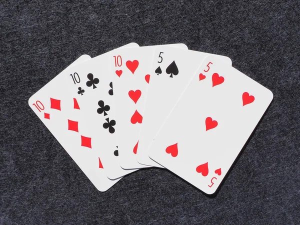 İskambil kağıdına yakın çekim. Pokerde kombinasyon, Full House. Gri bir arka planda plastik ya da kağıt kartlar. Kadife ya da mikrofiber kumaş arkaplan. Oyun konsepti için iyi fikir. Yüksek kaliteli makro.