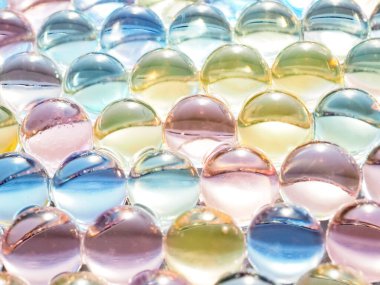 Çok renkli gökkuşağı ya da parlak, şeffaf yuvarlak yuvarlak topların yakın çekimi. Renkli kristal topların dokusu arka planda. Yüksek kaliteli makro fotoğrafçılık.