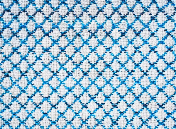 Close-up of the white blue diamond shaped fabric textile texture, background and wallpaper. The texture of white blue fabric textile texture upholstery of furniture. High-quality macro photography.