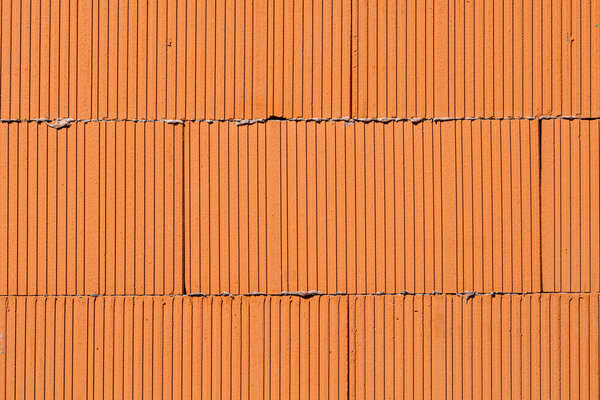Brick texture, three rows of orange bricks close up view