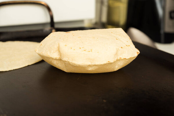 Tortillas, cooking on the griddle ready to have a Mexican meal