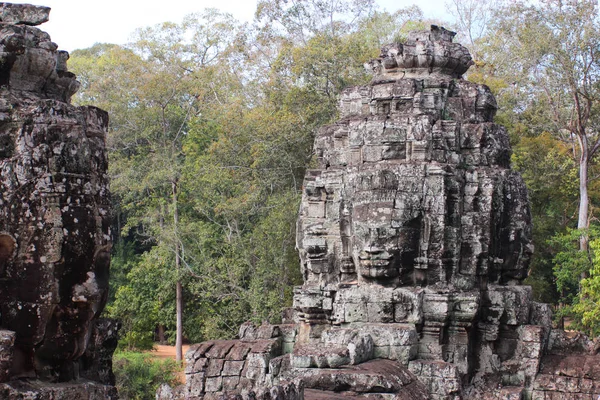 Руины старого искушения с каменными головами и лицами в Камбоди — стоковое фото
