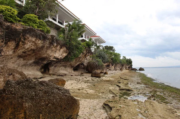 Sandy plaj, tropikal ağaçlar ve t kırmızı kiremit ile beyaz evler