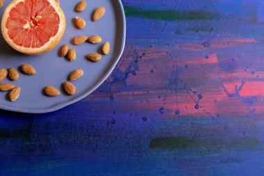 Mavi arka planda greyfurtlar ve süslü tabaklar, meyve suyu yapmak ya da evde bir öğleden sonra eğlenmek için.