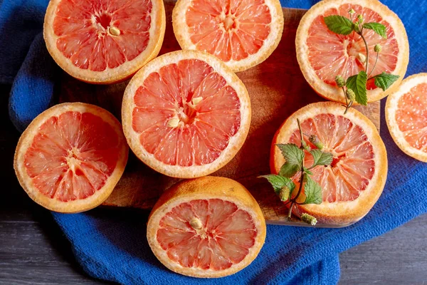 Grapefruits on blue background and decorated plate, to make juices or to enjoy in an afternoon at home