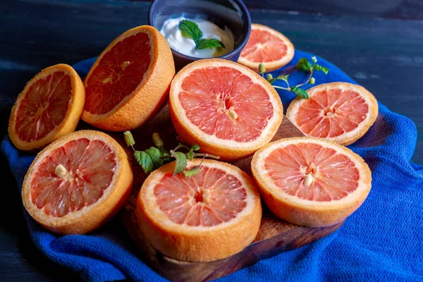 Grapefruits on blue background and decorated plate, to make juices or to enjoy in an afternoon at home