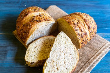 Mavi masadaki zanaatkar tohumu ekmeği, tapas veya sandviç için idealdir.