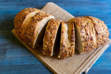 Mavi masadaki zanaatkar tohumu ekmeği, tapas veya sandviç için idealdir.