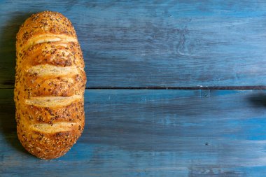 Mavi masadaki zanaatkar tohumu ekmeği, tapas veya sandviç için idealdir.