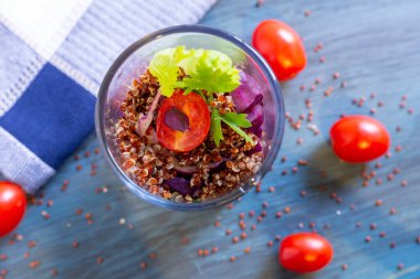 Kırsal masada domatesli kırmızı kinoa salatası. Süper yiyecek ve sağlıklı yeme konsepti.