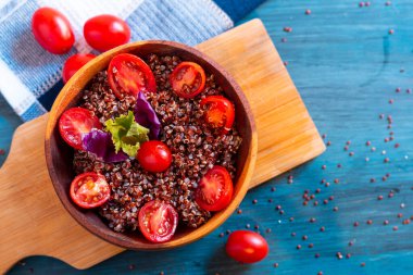 Kırsal masada domatesli kırmızı kinoa salatası. Süper yiyecek ve sağlıklı yeme konsepti.