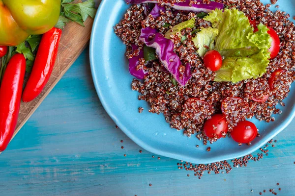 Kırsal masada domatesli kırmızı kinoa salatası. Süper yiyecek ve sağlıklı yeme konsepti.