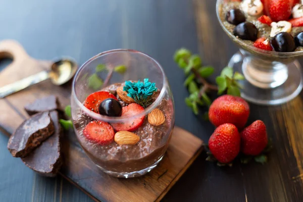 Chocolate pudding with chia, chocolate and strawberries on a blue table