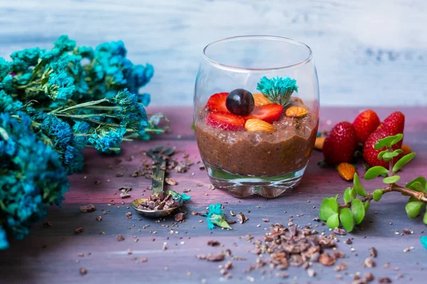 Chocolate pudding with chia, chocolate and strawberries on a blue table