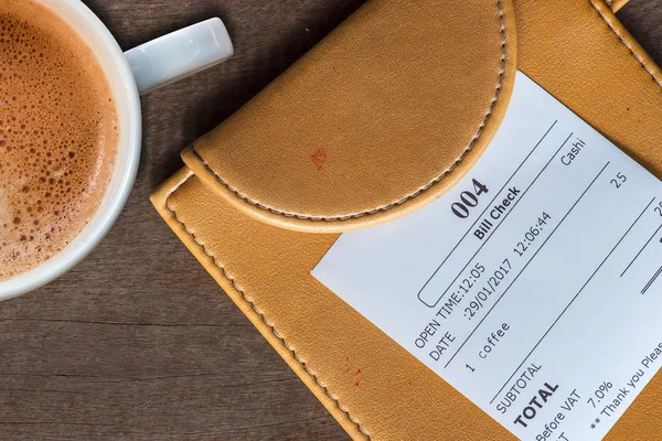 Taza de café y recibo factura en el pago de la carpeta — Foto de Stock