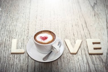 Beyaz fincan kahve kırmızı kalp tepesi ile