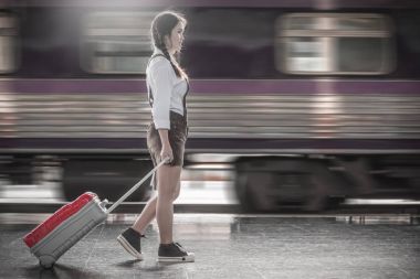 Bir tren istasyonunda yürüyen genç ve güzel kadın