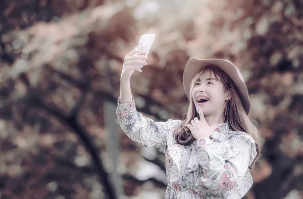 Souriant jeune femme prenant selfie avec smartphone sous le soleil — Photo