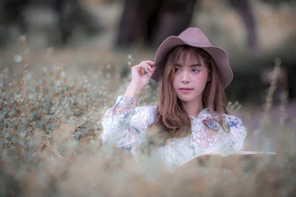 공원에 앉아 모자를 착용 하는 젊은 여자 — 스톡 사진
