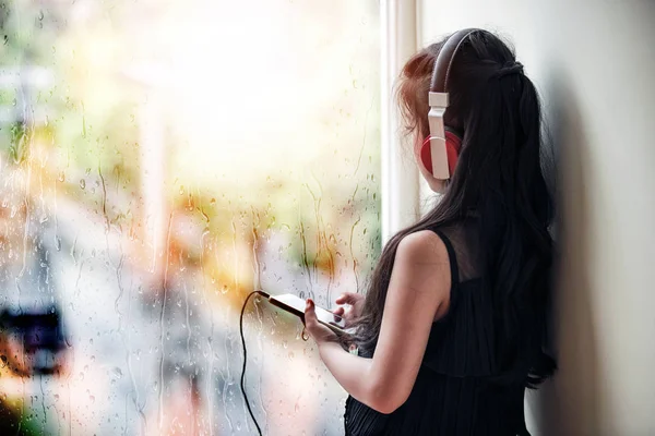 Adolescente com fones de ouvido ouvindo a música dentro de uma sala — Fotografia de Stock