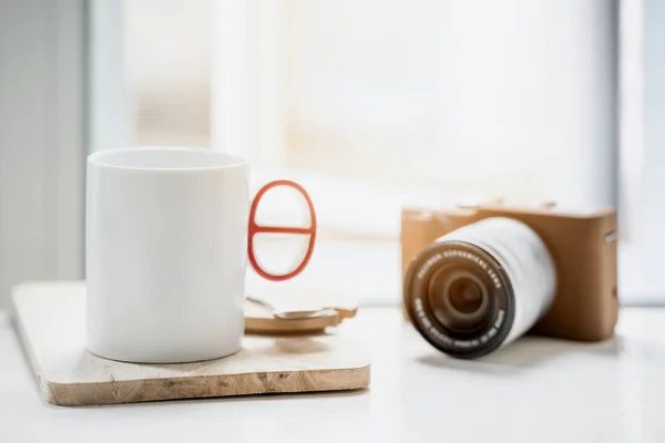 Чашка кави або чаю і класична камера на білому столі — стокове фото