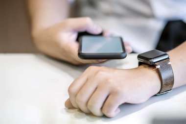 İşadamı smartphone kullanarak bağlan smartwatch süre çalışma için