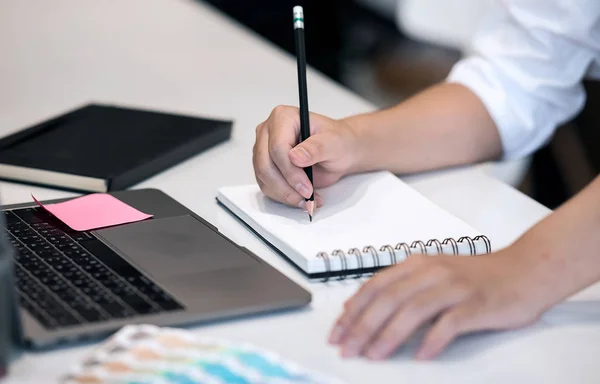 Imagen recortada del hombre escribiendo en el cuaderno mientras trabajaba en la oficina — Foto de Stock