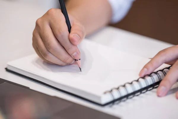 Beskuren bild av människan skriver på anteckningsboken medan du arbetar på kontoret — Stockfoto