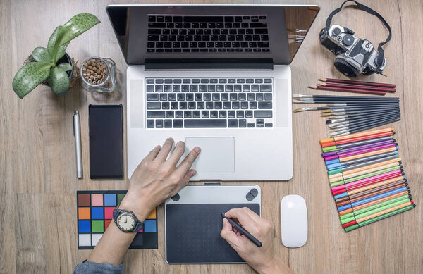 designer using laptop computer and graphics tablet at home offic