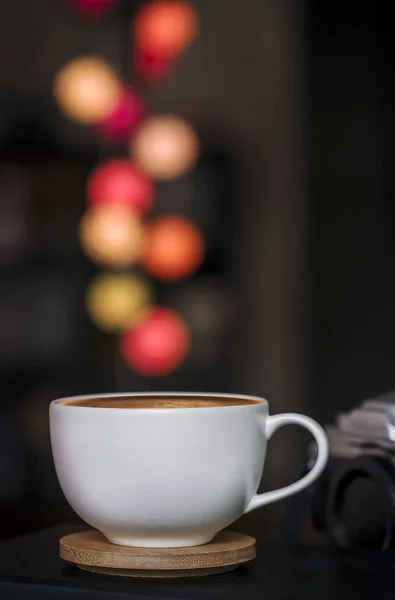 Fermer tasse à café blanche sur une assiette en bois et flou coloré ligh — Photo