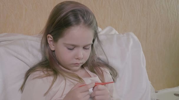 Симптомы лихорадки и коронавируса, девушка измеряет температуру тела. Расстроенная девушка смотрит на цифровой термометр в руке, концепцию обычной простуды и гриппа — стоковое видео
