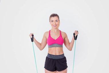 Pembe bluzlu genç kadın, beyaz arka planda egzersiz yapan şort ve prezervatifler.