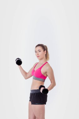İzole edilmiş beyaz arka planda ağırlık kaldıran genç bir kadın..