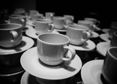 Yemek konsepti siyah beyaz. Toplantıda kahve fincanları ve tabaklar yığıldı..