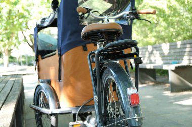 Close Up of wooden cargo bike with a tent parking in a park in Berlin. Background blurred. clipart