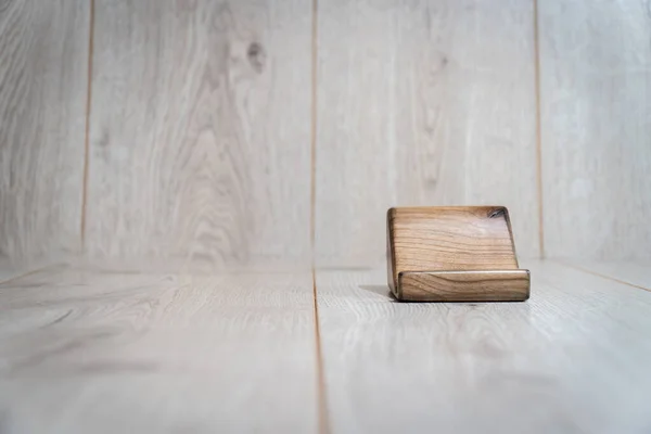 Wooden stand for phone on a wooden background