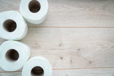 Ahşap arka planda tuvalet kağıdı ruloları