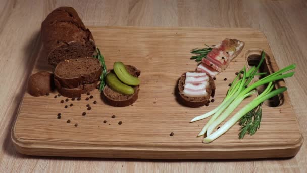 Three sandwiches in the Russian style: with lard, with fish, with pickles and green onions, and three glasses with a traditional alcoholic drink. Still life on a white oak board. — Stock Footage Three Sandwiches Russian Style Lard Fish Pickles Green Onions Three Stock Video