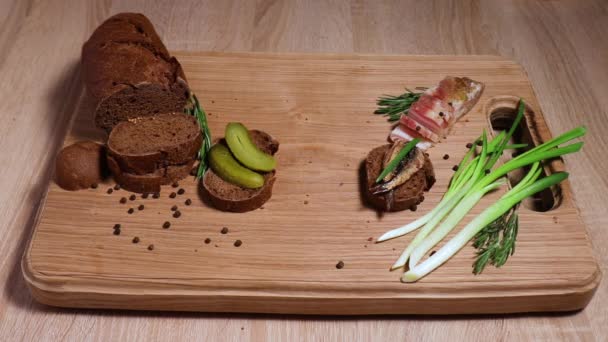 Three sandwiches in the Russian style: with lard, with fish, with pickles and green onions, and three glasses with a traditional alcoholic drink. Still life on a white oak board. — Stock Footage Three Sandwiches Russian Style Lard Fish Pickles Green Onions Three Royalty Free Stock Footage