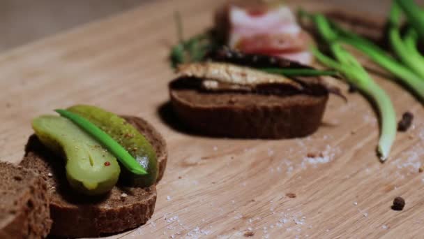 Three sandwiches in the Russian style: with lard, with fish, with pickles and green onions, and three glasses with a traditional alcoholic drink. Still life on a white oak board. — Stock Footage Three Sandwiches Russian Style Lard Fish Pickles Green Onions Three Stock Footage