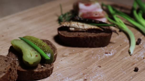 Three sandwiches in the Russian style: with lard, with fish, with pickles and green onions, and three glasses with a traditional alcoholic drink. Still life on a white oak board. — Stock Footage Three Sandwiches Russian Style Lard Fish Pickles Green Onions Three Stock Video