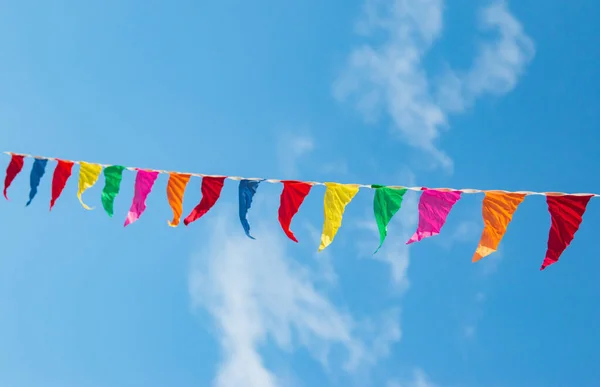 multi-colored flags against a blue sky