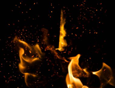 Siyah arkaplanda kıvılcımlar saçan ateş alevleri