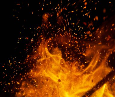 Siyah arkaplanda kıvılcımlar saçan ateş alevleri