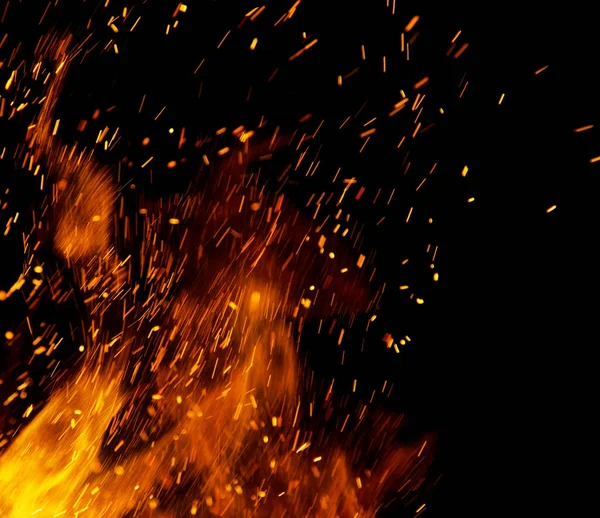 Siyah arkaplanda kıvılcımlar saçan ateş alevleri