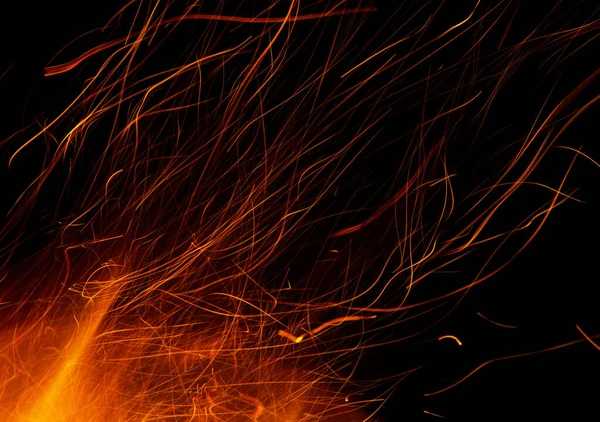 黒地に火花を散らし炎を放つ — ストック写真