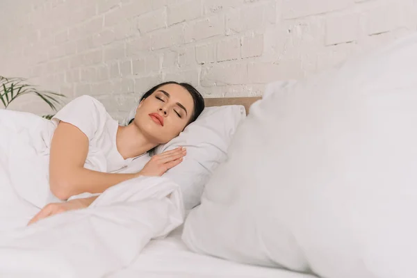 Seçici odak noktası beyaz yatakta uyuyan güzel kadın.
