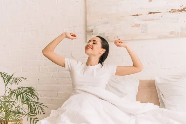 Pretty Smiling Woman Stretching Closed Eyes While Sitting Bed Blanket — Stock Photo, Image